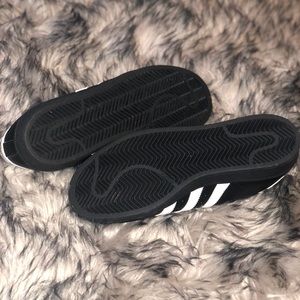 Black Adidas with white stripes
